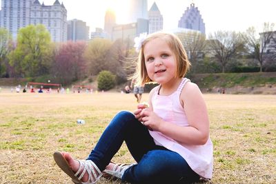 Portrait of happy girl sitting in park