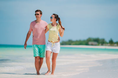 Full length of couple walking on beach