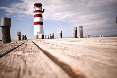 Surface level of lighthouse by sea against sky