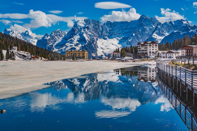 Reflection of snowcapped mountains in lake against sky during winter