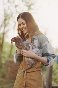 Portrait of smiling young woman holding bird