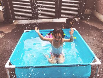 High angle view of girl playing in wading pool