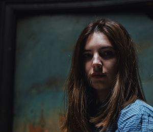 Close-up portrait of woman against wall