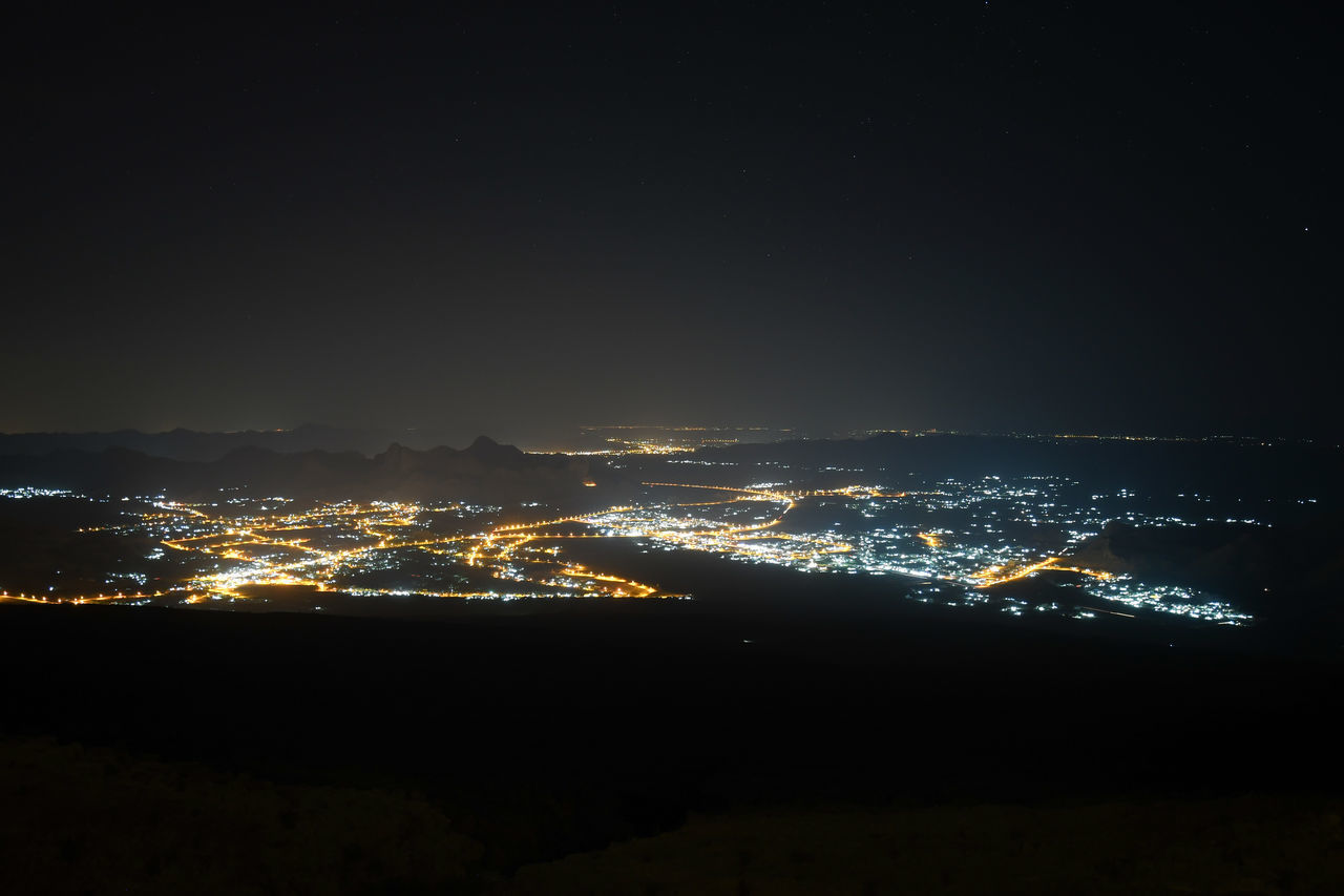 ILLUMINATED CITYSCAPE AGAINST SKY AT NIGHT