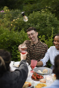Portrait of smiling friends having food at home