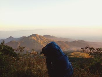 Man on mountain against sky during sunset