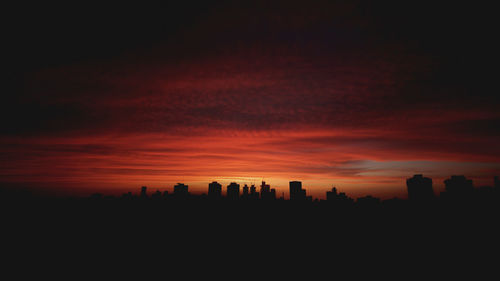 Silhouette cityscape against sky during sunset