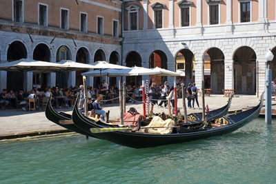 People on boats in canal along buildings