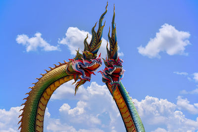  low angle twin stucco painted as a large serpent at pra kai keaw wang nakin,  udon thani, thailand.