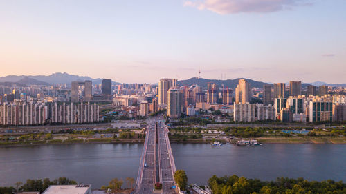 View of buildings at waterfront against cloudy sky