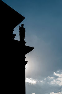 Low angle view of silhouette statue of building against sky