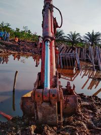 Old rusty metal by river against sky