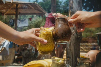 Midsection of people holding ice cream in jar