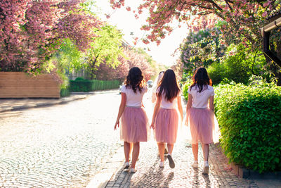 Rear view of women walking on footpath