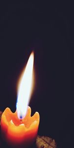 Close-up of lit candle in the dark