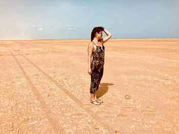 Full length of woman standing on sand
