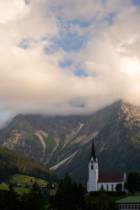 Scenic view of buildings by mountains against sky