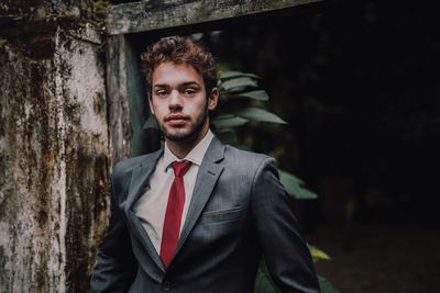 Portrait of young man standing at home