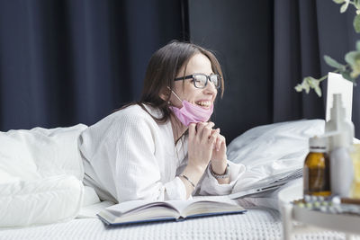 Young woman looking away while sitting on table