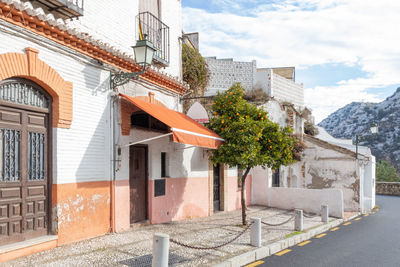 Street by buildings against sky