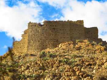 Low angle view of old building against cloudy sky