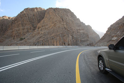 Cars on road against mountain range