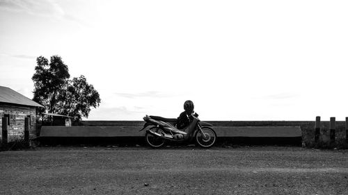 Man cycling on bicycle against sky