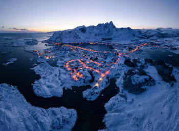 Scenic view of snow covered land against sky during sunset