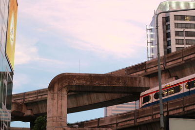 Low angle view of bridge in city against sky