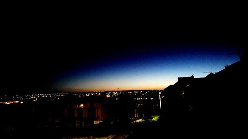 High angle view of silhouette buildings against sky at night