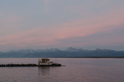 Scenic view of an house on the sea coast against sky during sunset