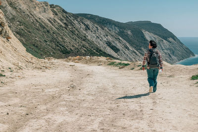 Rear view of man walking on mountain