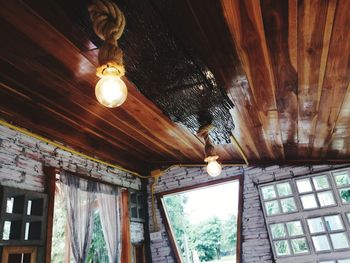 Low angle view of illuminated pendant light hanging from ceiling