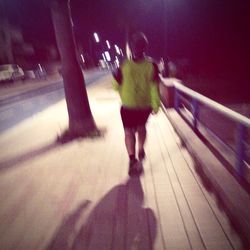Rear view of woman walking at night