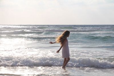 Full length of man playing at beach against sky