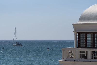 Sailboat sailing on sea against clear sky