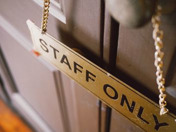 Close-up of text hanging on door