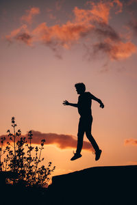 Full length of silhouette man jumping against sky during sunset