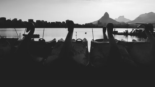 Group of people on boats in sea against sky