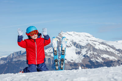 Rear view of boy standing on snow covered mountain