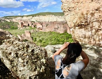 Rear view of woman standing on cliff