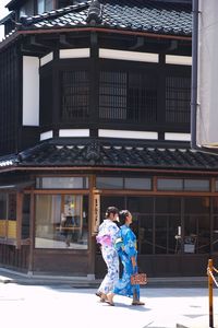 Woman with umbrella standing in city