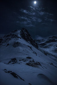 Scenic view of snowcapped mountains against sky at night