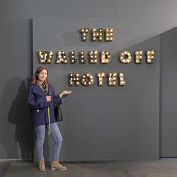 Portrait of smiling woman standing against wall