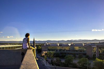 Rear view of a woman overlooking buildings