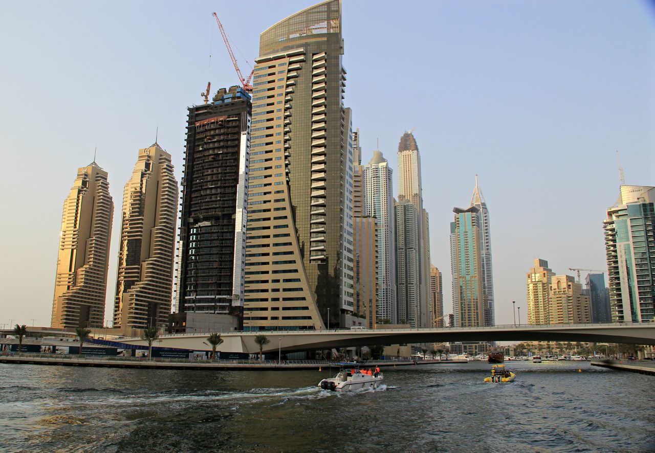 building exterior, architecture, built structure, water, city, clear sky, waterfront, skyscraper, river, nautical vessel, cityscape, modern, office building, tall - high, urban skyline, tower, city life, sea, capital cities, travel destinations