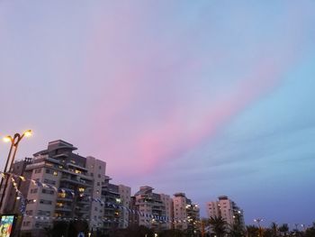 Low angle view of illuminated buildings against sky during sunset