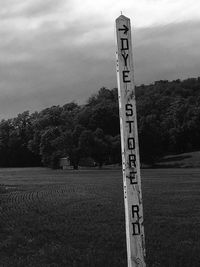 Information sign on landscape against cloudy sky