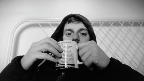 Portrait of young man drinking glass