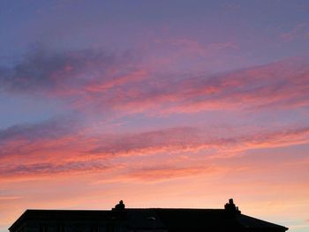 Silhouette of building against sky at sunset